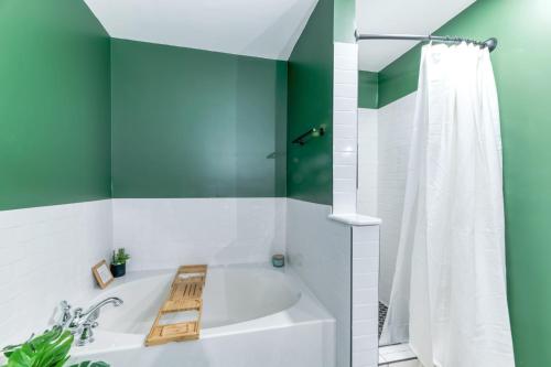 een badkamer met een wit bad en groene muren bij Hilltop Hideaway - Pool - Jacuzzi - Ping Pong - 12 guests - Fireplace - Mountain Views - Pets are allowed by request in Roseland