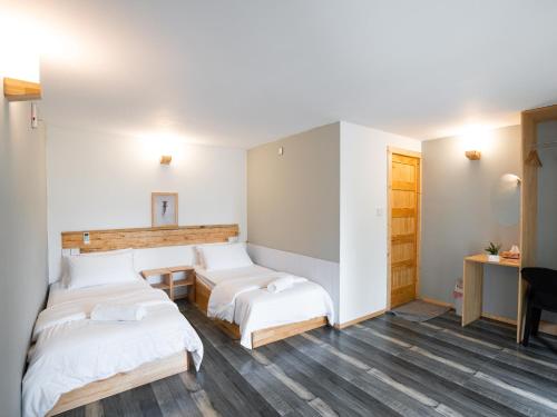 Cette chambre comprend 3 lits, une table et un bureau. dans l'établissement Kanditheemu Inn, à Kanditheemu