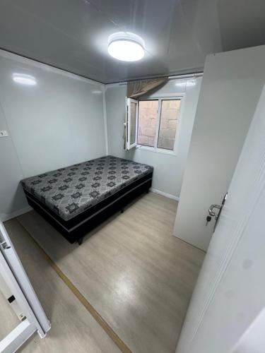 een slaapkamer met een bed in het midden van een kamer bij Residencial Manhattan in Passo Fundo