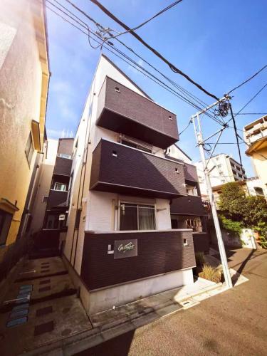 a building with a black and white building at Mossy Nest Negishi I 鶯谷駅徒歩7分 上野徒歩圏内 in Tokyo