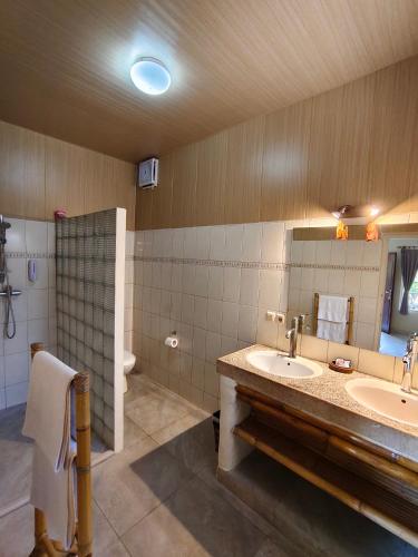 a bathroom with two sinks and a mirror at Hotel Chonos in Lovina
