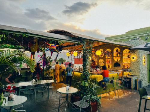 a group of people sitting at tables in a restaurant at Viajero Oaxaca Hostel in Oaxaca City