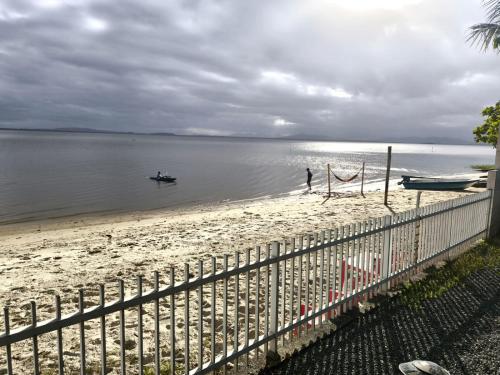 een man op een strand met een boot in het water bij Refúgio Testoni in São Francisco do Sul