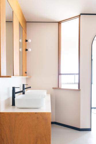 a bathroom with a sink and a mirror at ぷふか映月東向島 Pufuka Eigetsu Higashi Mukoujim in Tokyo