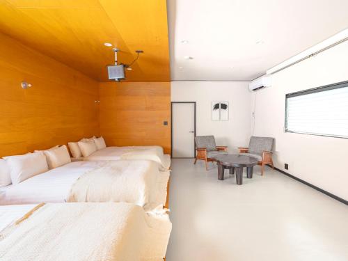 a bedroom with two beds and a table in it at ぷふか映月東向島 Pufuka Eigetsu Higashi Mukoujim in Tokyo