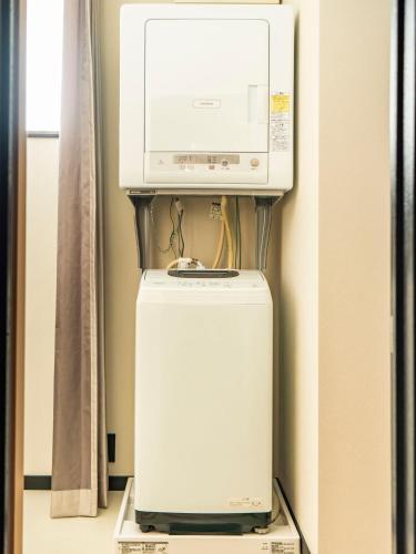 a microwave sitting on top of a refrigerator at ぷふか映月東向島 Pufuka Eigetsu Higashi Mukoujim in Tokyo