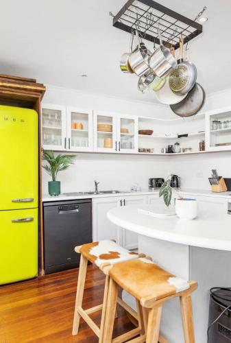a kitchen with a white counter and a yellow door at 5 North Freo 2BR Supercool Pad & Parking in North Fremantle