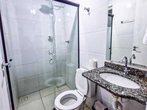 a bathroom with a shower and a toilet and a sink at Apto Confortável - Supermercado Bahamas ao lado in Uberaba