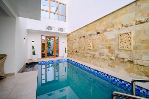 a swimming pool in a house with a brick wall at Danka Luxury Villa in Batam Center