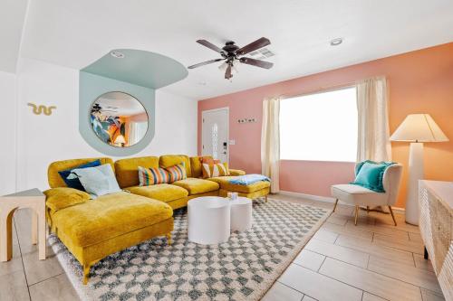 a living room with a yellow couch and a window at Spacious home w private pool & game room in Phoenix