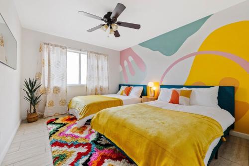 two beds in a room with a painting on the wall at Spacious home w private pool & game room in Phoenix
