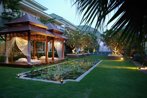 a garden with a gazebo and a pond of flowers at Palette Bangkok Natural Resort and Spa in Bangkok