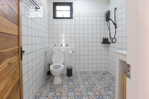 a bathroom with a toilet and a tiled floor at Coconut Breeze Villa #2 in Haad Chao Phao