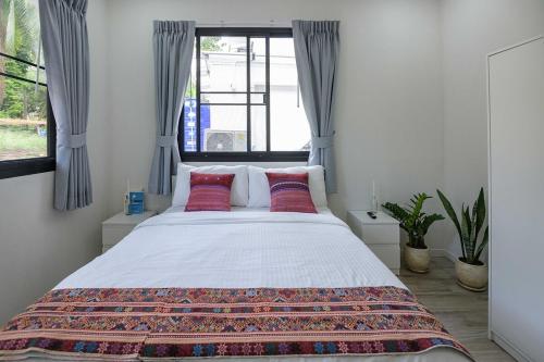 a bedroom with a large bed with red pillows at Coconut Breeze Villa #2 in Haad Chao Phao