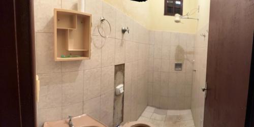 a bathroom with a shower with a sink and a toilet at Casa de praia in Itapemirim