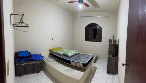 a room with two beds and a ceiling fan at Casa de praia in Itapemirim