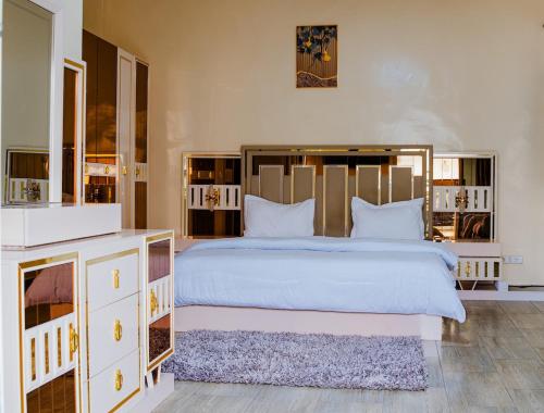 a bedroom with a large white bed with a large headboard at Camara Homes in Saint-Louis