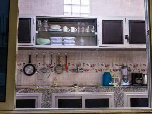 a kitchen counter with white cabinets and utensils at Camara Homes in Saint-Louis