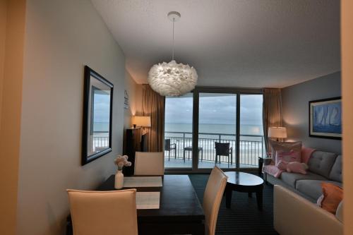 a living room with a couch and a dining room at Stylish 1BR Oceanfront Stay in the Heart of Myrtle Beach 3rd Fl of OO Resort in Myrtle Beach