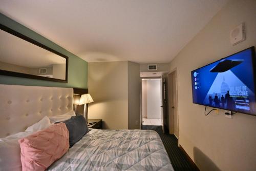 a bedroom with a bed and a flat screen tv at Stylish 1BR Oceanfront Stay in the Heart of Myrtle Beach 3rd Fl of OO Resort in Myrtle Beach