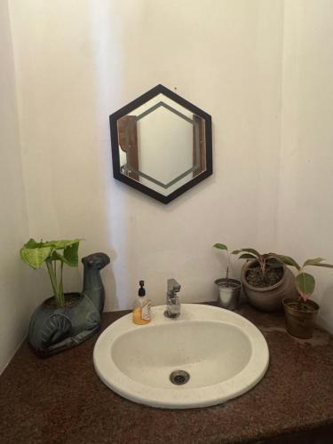 een badkamer met een wastafel en een spiegel aan de muur bij Fire Room Elements by Hexa stays in Trivandrum