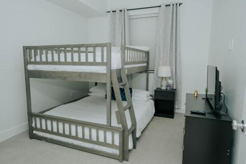 a bedroom with two bunk beds and a television at Luxury 2 bedroom 2 bath DT Stay in Salt Lake City