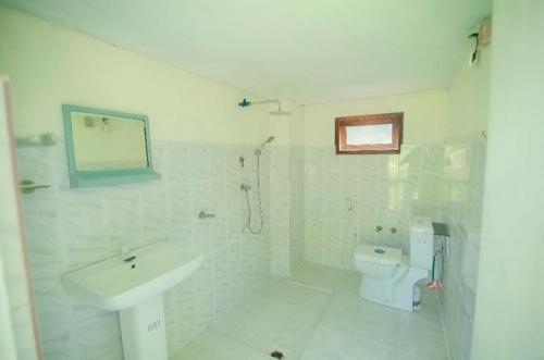a white bathroom with a sink and a toilet at Villa Ransanda in Warakagoda