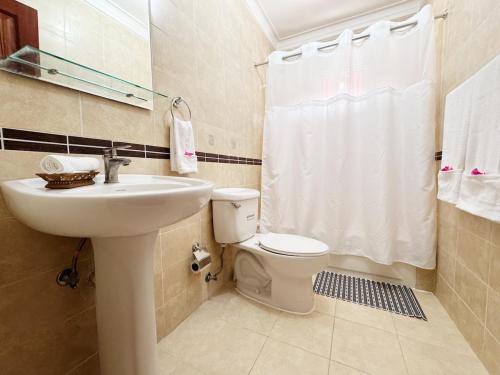 a bathroom with a white sink and a toilet at Haven Villa Retreat Jacuzzi Oasis in Mata los Indios