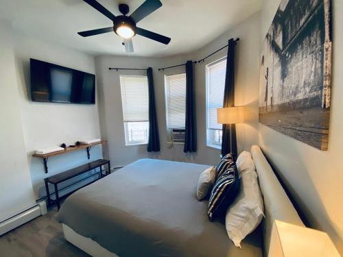 ein Schlafzimmer mit Bett und Deckenventilator in der Unterkunft NYC Oasis in Mott Haven