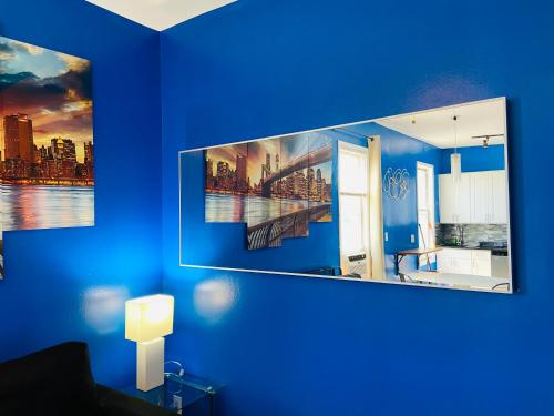 ein Zimmer mit einer blauen Wand mit zwei Bildern darauf in der Unterkunft NYC Oasis in Mott Haven