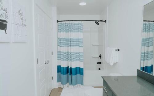 a bathroom with a shower with a blue and white shower curtain at Luxury 2 bedroom 2 bath DT Stay in Salt Lake City