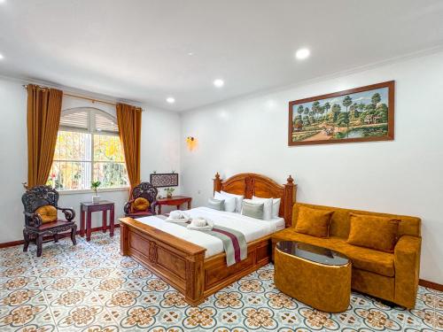 une chambre avec un lit et un canapé dans l'établissement Piseth Private Villa Hotel, à Battambang
