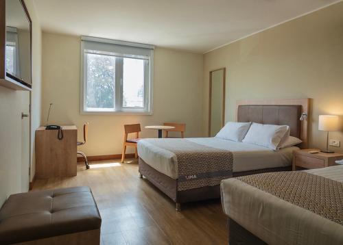 una camera d'albergo con due letti e una finestra di Xima Lima San Isidro a Lima