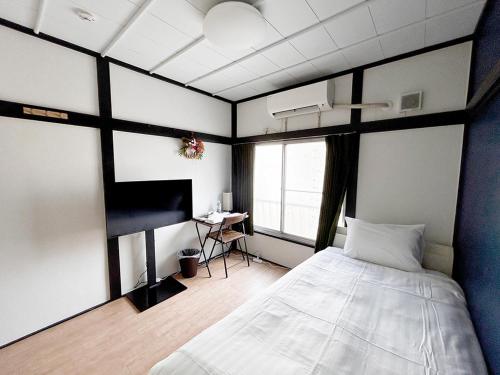 a bedroom with a bed and a desk in it at D旅館　Dryokan in Tokyo