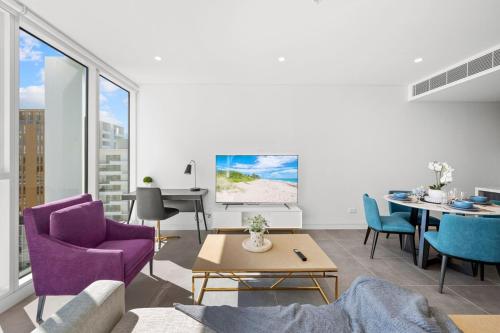 a living room with a purple couch and a table at SOP 18 Stylish and Cosy 2 Bedroom Apt in Sydney