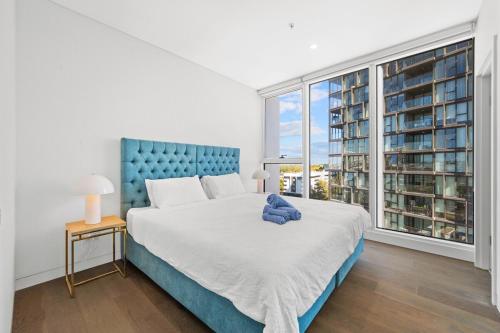 a bedroom with a large bed and a large window at SOP 18 Stylish and Cosy 2 Bedroom Apt in Sydney