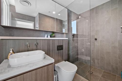 a bathroom with a sink and a toilet and a shower at SOP 18 Stylish and Cosy 2 Bedroom Apt in Sydney