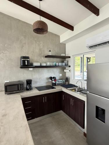 a kitchen with a sink and a refrigerator at Casa kai in Agujas