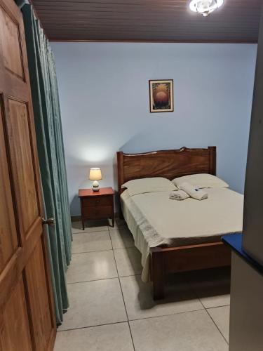 a bedroom with a bed and a table and a lamp at Yamis home in General Viejo