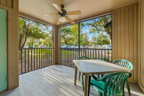 a screened porch with a table and chairs and a ceiling fan at Family-friendly condo in Tampa