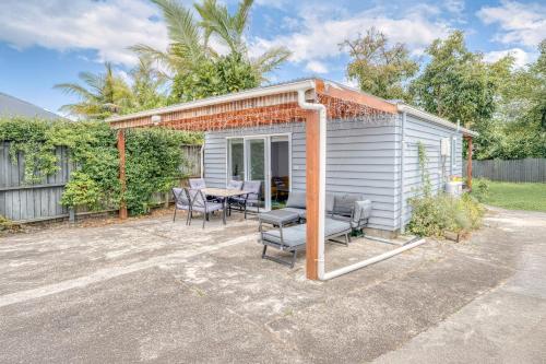 a small white shed with a table and chairs at Auckland Urban Escape - Central, Connected & Comfy in Auckland