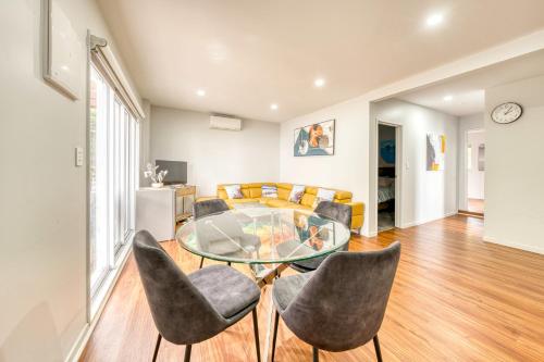 a dining room with a glass table and chairs at Auckland Urban Escape - Central, Connected & Comfy in Auckland