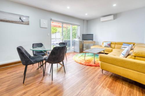 a living room with a couch and a table and chairs at Auckland Urban Escape - Central, Connected & Comfy in Auckland