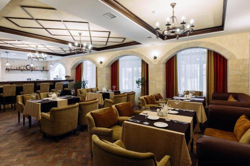 リャザンにあるAragon Hotelのテーブルと椅子のあるレストラン、バー