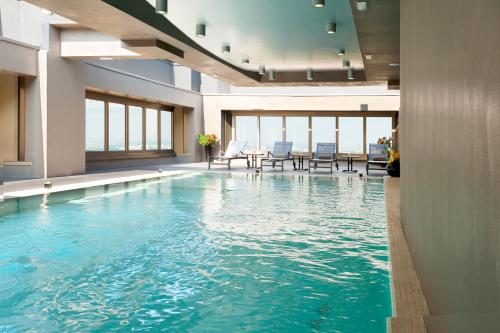 an indoor pool with blue water in a building at Best Western Plus The Hub Hotel in Milan