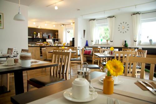 a restaurant with tables and chairs and a clock on the wall at Pension Sperlhof in Erding
