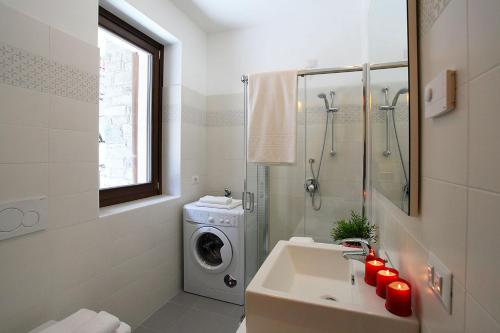 a bathroom with a sink and a washing machine at Parco dei Cervi Terrazzo in Menaggio