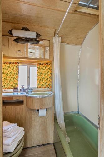 a bathroom with a shower and a sink and a tub at Starlite Vintage Resort in Buckskin Joe