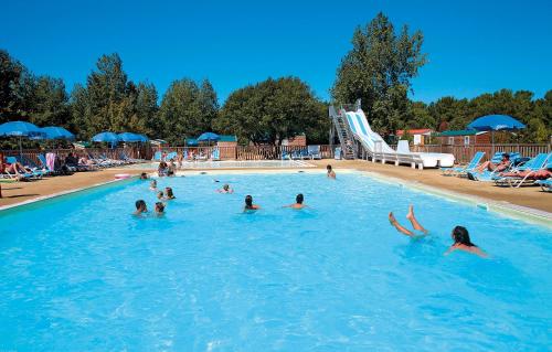 um grupo de pessoas a nadar numa piscina em Domaine Résidentiel de Plein Air Odalys Les Demoiselles em Saint-Hilaire-de-Riez