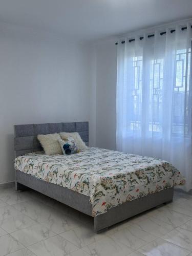 a bed in a white room with curtains and a bed sidx sidx sidx at Serene 3-Bedroom House in Pridelands, Nairobi in Syokimau